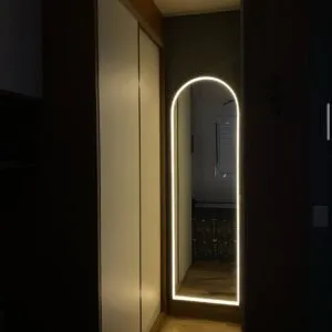 Vista completa de espejo arqueado con marco de herrería y luz LED neón decorativa