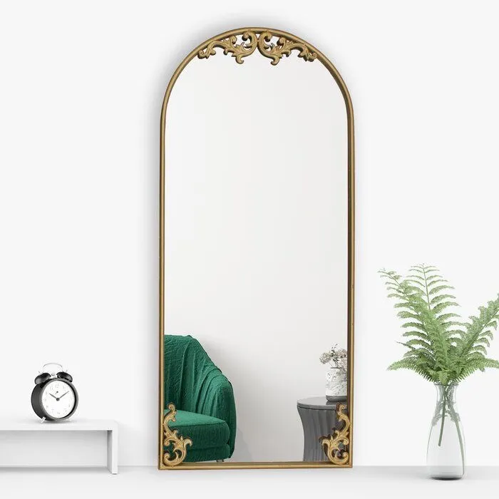 Vista de detalle de espejo arqueado vintage con marco de herrería decorativo