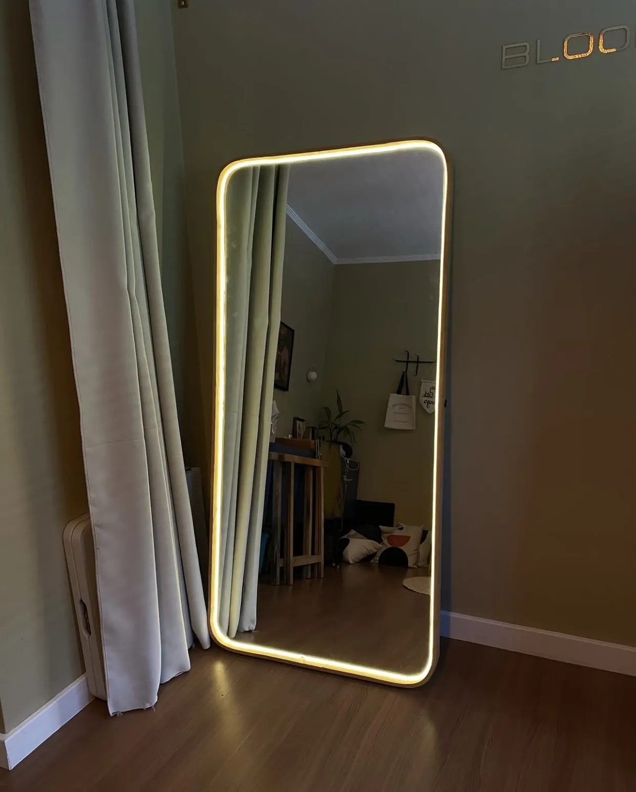 Primer plano de espejo arqueado con marco de herrería y luz LED neón